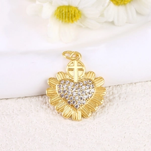 Macro view of gold plated heart pendant with cross top and inlaid cubic zirconia stones
