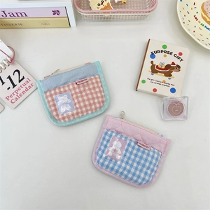 Close-up of quilted fabric coin purses with transparent card slots and bear patterns