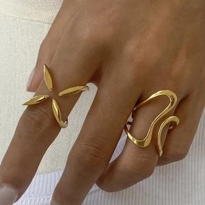 Detailed view of two gold stainless steel rings with floral and wavy line designs