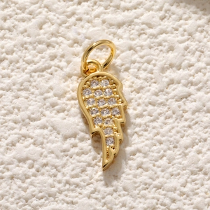 Détail du pendentif aile d'ange doré serti de pierres de zircone cubique claires