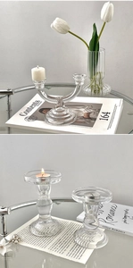 Close-up of elegant clear glass multi-arm and single candle holders for dining decor