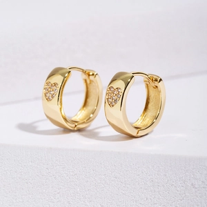Macro detail of gold plated heart hoop earring with micro-paved sparkling cubic zirconia