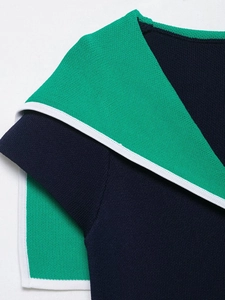 Detail of navy knit top with green contrast collar and white edge stitching