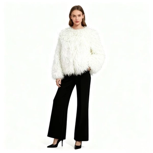 Full body shot of a white faux fur coat paired with black wide-leg trousers for a chic look