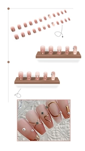 Detail of pink gradient press-on nails with pearls, gold hearts, and crystals decorations