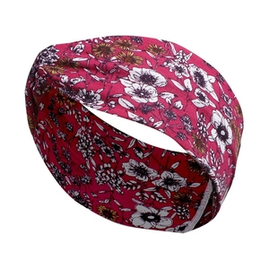 Detail view of a wide red cotton yoga headband with white and yellow floral patterns