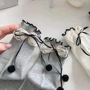Detail of lace trim and satin bow on grey and white cotton knit crew socks