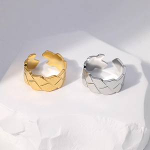 Close-up of gold and silver stainless steel rings with geometric diamond texture