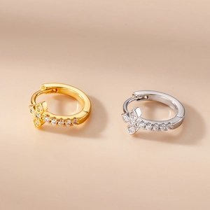 Detailed macro view of cross-shaped earrings featuring brilliant cubic zirconia in gold and silver