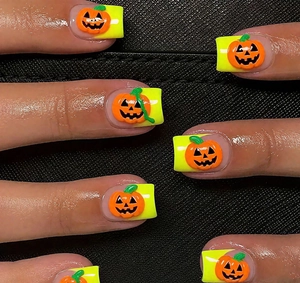 Makroaufnahme von 3D Halloween Nailart mit geprägten Kürbissen auf neongrünen Nägeln