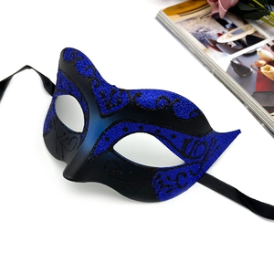 Detail of blue and black gradient masquerade mask with glitter patterns and silk ribbons