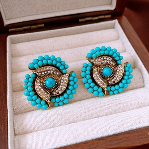 Detailed macro view of vintage turquoise flower earrings with micro-inlaid rhinestones