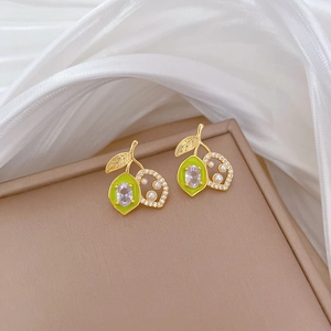 Detail of fruit cherry earrings with green zircon and white pearl on silk
