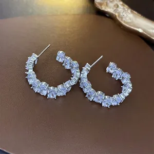 Minimalist S925 silver C-shaped hoop earrings with oval CZ stones on dark leather