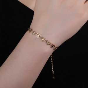 Bracelet pour femme en acier doré 18 carats avec cœurs évidés et motifs rayons de soleil