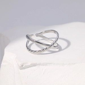 Detail of silver crisscross ring featuring polished and twisted rope texture bands