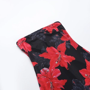 Detailed close-up of realistic red lily floral print on a sexy strapless tube dress