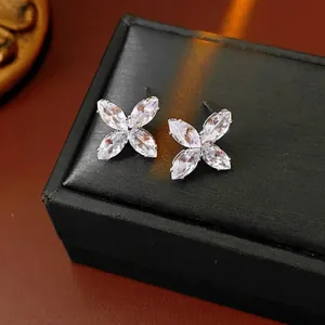 Boucles d'oreilles fleur en zircon et aiguilles en argent sur un écrin noir élégant