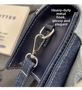 Détail du crochet en métal argenté et des coutures en denim du sac à main