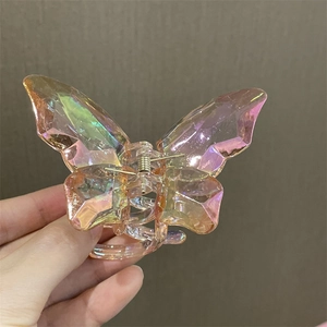 Primer plano de una pinza para el cabello de mariposa iridiscente con degradado de color