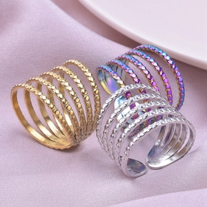 Detail of multi-layer stainless steel rings in gold, silver and rainbow on silk fabric