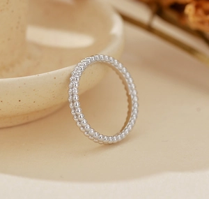 Macro detail of a minimalist S925 sterling silver double row beaded band ring for women
