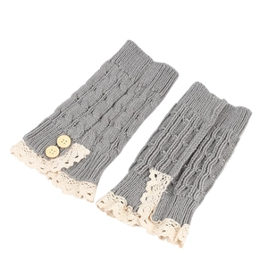 Detail of grey knitted leg warmers with beige lace trim and wooden button accents