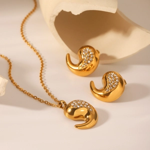 Détail de la parure collier et boucles d'oreilles goutte dorée avec oxydes de zirconium