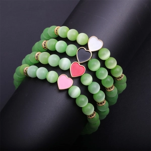 Set of four green cat eye beaded bracelets with colorful enamel heart pendants