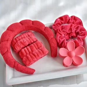 Pink plush spa headband set with wristbands and flower hair claw clip on a tray