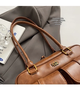 Close-up of retro brown leather handbag featuring dual flap pockets and gold hardware