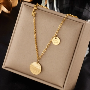 Detailed view of gold chain necklace with Good Luck and Heart Smile engraved pendants