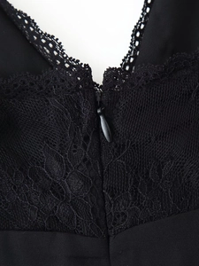 Detailed close-up of the black lace patchwork and hidden back zipper on a V-neck dress