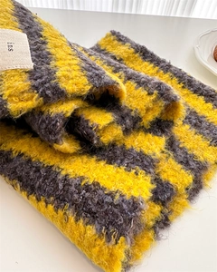 Close-up of yellow and grey striped knit scarf with soft fluffy texture and ins label