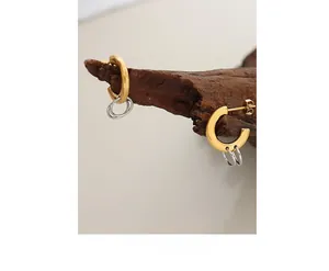 Detail of minimalist mixed-tone interlocking hoops on a rustic wooden display branch