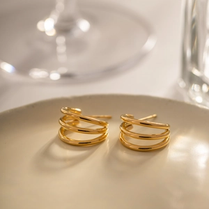 Modern 18K gold plated triple hoop stainless steel earrings on a ceramic tray