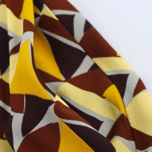 Vista macro de tela con estampado geométrico marrón y amarillo con detalles de textura