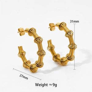 Detail view of gold spiral hoop earrings with dimensions 31mm and weight 9g shown on white