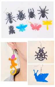 Detail of DIY animal resin earrings featuring glitter insects like butterflies and dragonflies