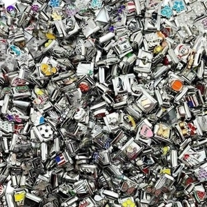 Macro view of assorted vintage stainless steel charms with colorful enamel patterns