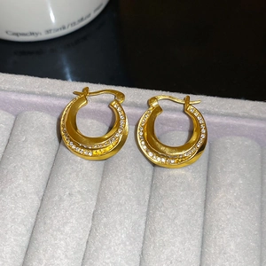 Detailed view of double layered gold hoop earrings with sparkling cubic zirconia inlay