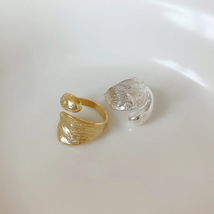 Detailed macro view of gold and silver minimalist open rings with lava fluid texture