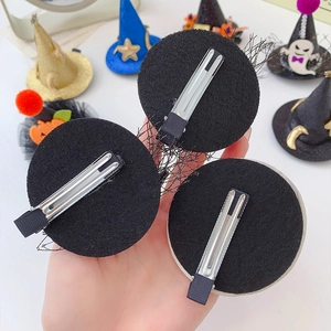 Handheld view of Halloween mini wizard hat hair clip with pumpkin and ghost details