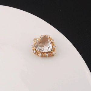 Macro shot of gold-plated 3D heart pendant featuring a large central zircon and halo setting