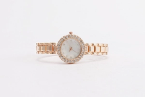 Detailansicht der roségoldenen Uhr mit Kristalllünette und Zifferblatt aus Perlmutt