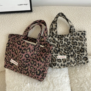 Close-up of leopard print tote bag texture and By sozakka woven label detail