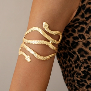 Golden double-headed snake arm cuff with textured scales worn over a leopard print outfit