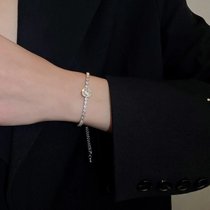 Detail of silver zircon bracelet with round cluster and adjustable pull chain on wrist