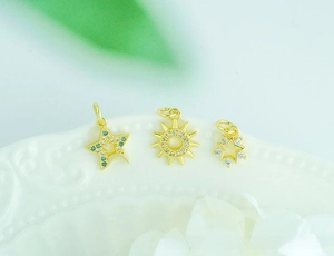 Detailed macro view of 18K gold plated celestial sun and star pendants with zircons
