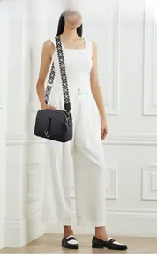 Fashionable black pebbled leather crossbody bag with geometric woven strap on a model